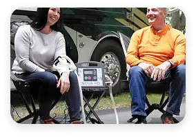 Two people using a PEMF machine while camping